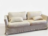 a white couch with two pillows on it in a room