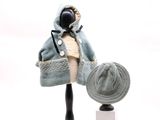 un mannequin coiffé d'un chapeau et vêtu d'un manteau, posé sur un socle