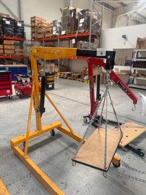 une grue posée sur un chariot dans un entrepôt