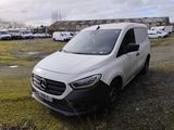 la camionnette blanche est garée dans un parking avec d'autres voitures
