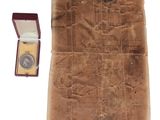 un bout de papier dans lequel se trouve une médaille d'or