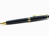 le stylo est noir, avec des finitions dorées et une pointe dorée