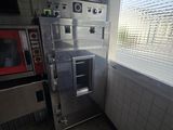 une photo d'une cuisine avec un micro-ondes et une fenêtre
