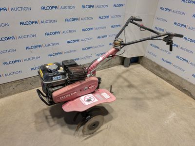 an image of a pink lawn mower parked in a garage