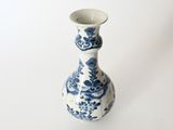 a blue and white vase sitting on a white surface