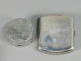 two pieces of silver and a rock on a white surface