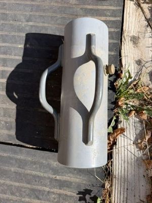 un récipient en plastique posé par terre à côté d'une planche de bois
