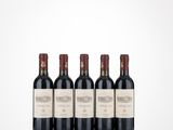 three bottles of red wine are lined up on a table