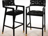une paire de tabourets de bar en cuir noir aux pieds dorés