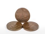 three bronze coins sitting on top of each other on a white surface
