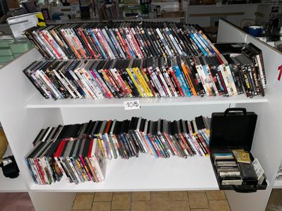 une étagère blanche remplie de DVD et d'autres films