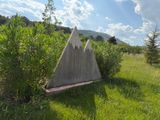 a concrete triangle in the middle of a grassy field