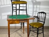 two chairs sitting next to a table with a chair on it