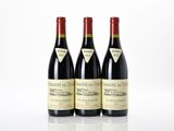 three bottles of red wine sitting next to each other on a table