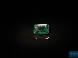 a green emerald stone on a black surface