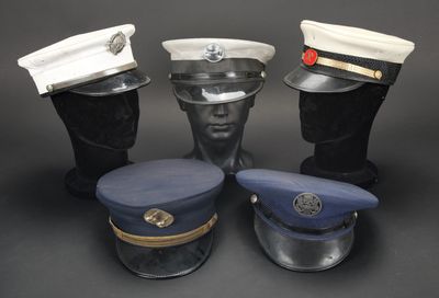 trois chapeaux et une casquette posés sur une table noire