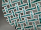 a close up of a plate with a woven design on it