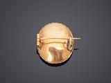 a close up of a gold broochle on a black surface