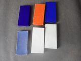 four different colored erases sitting on top of a gray surface