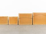a group of four wooden boxes sitting on top of a cement floor