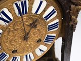 a gold clock with blue and white stripes on it