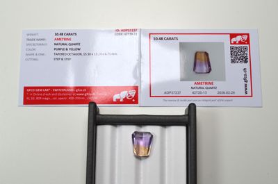 Une amétrine facettée trapèze, d'un poids de 10,48 cts, avec…