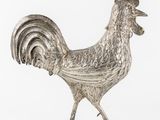 un coq argenté posé sur une surface blanche