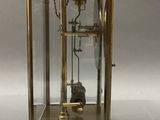 a gold clock with a glass case on top of it