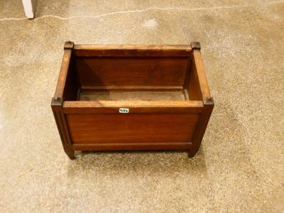 a small wooden box on the floor next to a chair