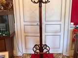 a coat stand in the middle of a room with a red carpet
