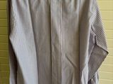 the shirt is hanging on a hanger in front of a wall