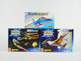 trois jouets Star Wars dans une boîte posée sur une surface blanche