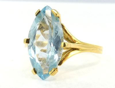 an image of a gold ring with a blue topazt stone