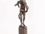 bronze statue of a boy holding a bird on a pedestal