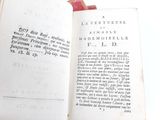 an open book on a table with a red cloth