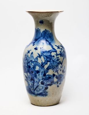 un vase bleu et blanc posé sur une surface blanche