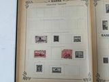an open book with stamps on it sitting on a table