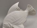 a white ceramic fish that is sitting on a table