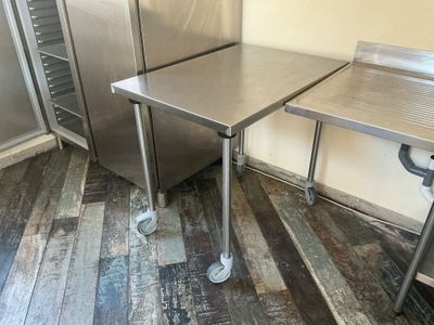 deux tables en acier inoxydable et un réfrigérateur dans la cuisine