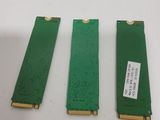 three pieces of green circuit board sitting on top of a white table