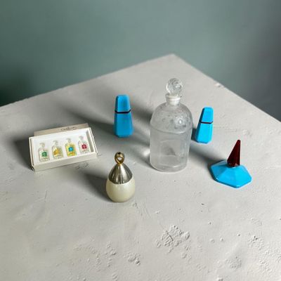 une table sur laquelle se trouvent une petite bouteille contenant un liquide et un petit objet
