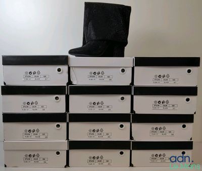 une pile de cartons sur laquelle est posée une paire de bottes