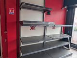 a red wall in a store with shelves on it