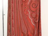 an image of a red paisley scarf hanging on a clothes rack