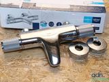 a silver airbrush sitting on a table next to a box