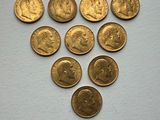 a close up of a bunch of gold coins on a white surface