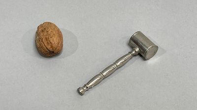 a nut and a hammer on a white surface
