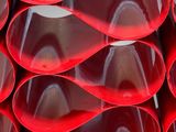 a red vase that has a lot of different shapes on it