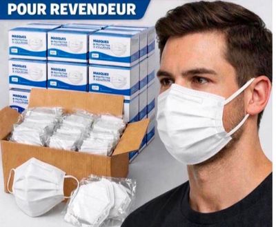 un homme portant un masque, à côté d'une boîte de masques jetables
