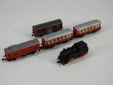 trois petits trains sur une surface blanche ; l'un est rouge et l'autre est noir